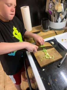 Cooking Like a Chef Camp participant learns to chop celery.