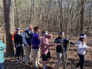 blindfolded students follow rope in the woods