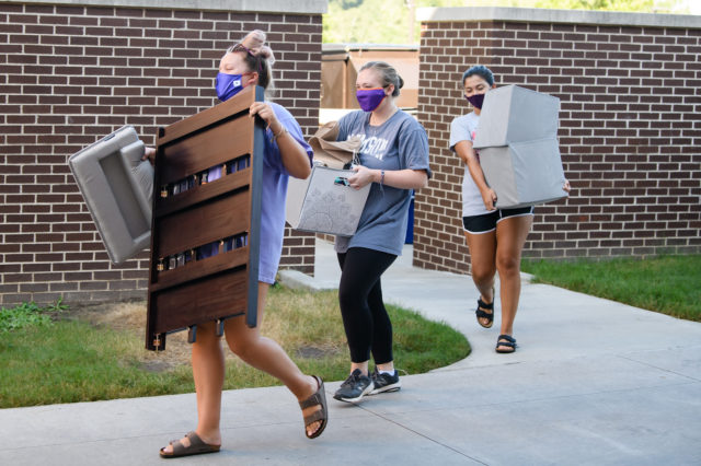 Clemson students carrying furniture and boxes during move-in weekend 