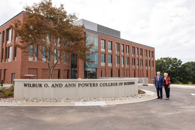 Billy and Ann Powers stand beside new signage for the College of Business