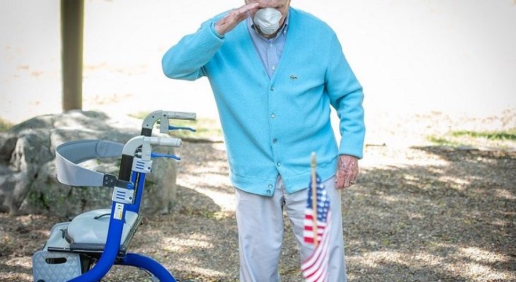 Ben Skardon, 102, salutes after placing a flag on a stone engraved with the name of Henry Leitner during a flag-placing ceremony at Clemson University’s Scoll of Honor
