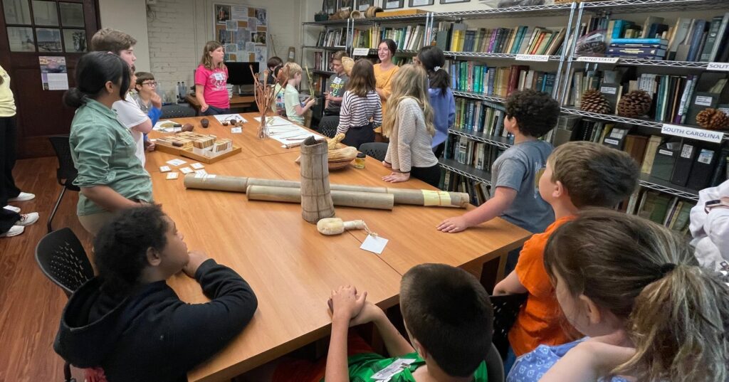 Children surround a work table in the Clemson Herbarium.