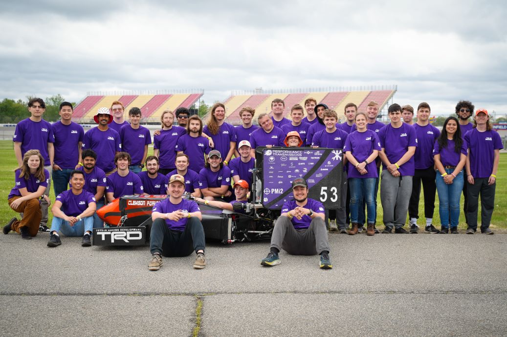 Clemson Formula SAE team stands together with their formula race car, Tiger 24