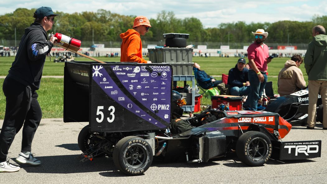 CUFSAE team members walking Tiger 24 to to starting line of the competition