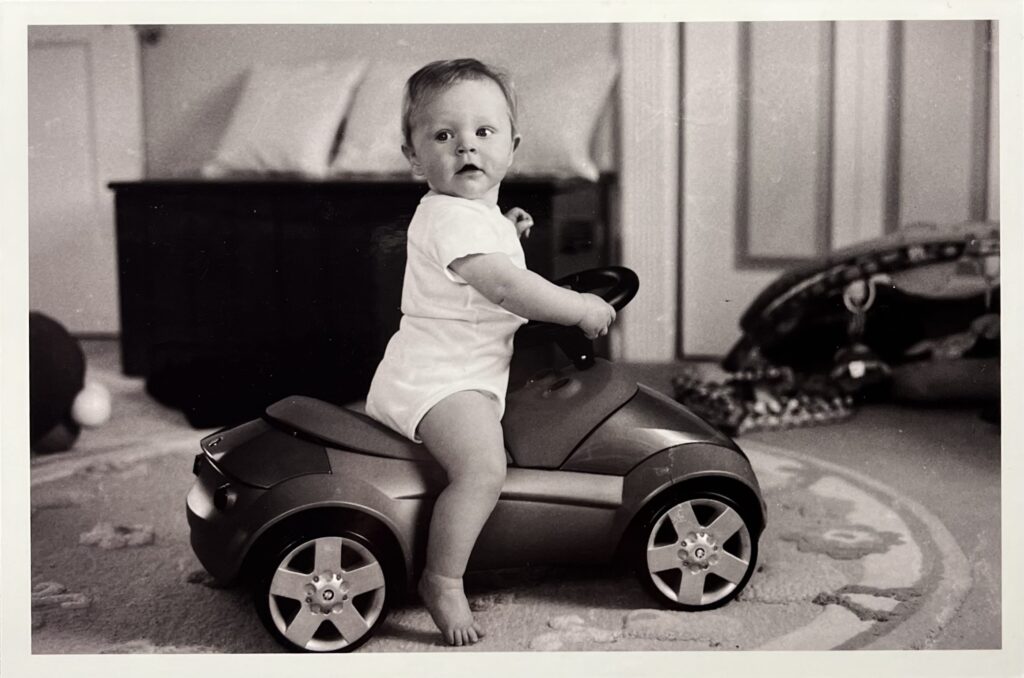 Bell as a young child playing with a toy car.
