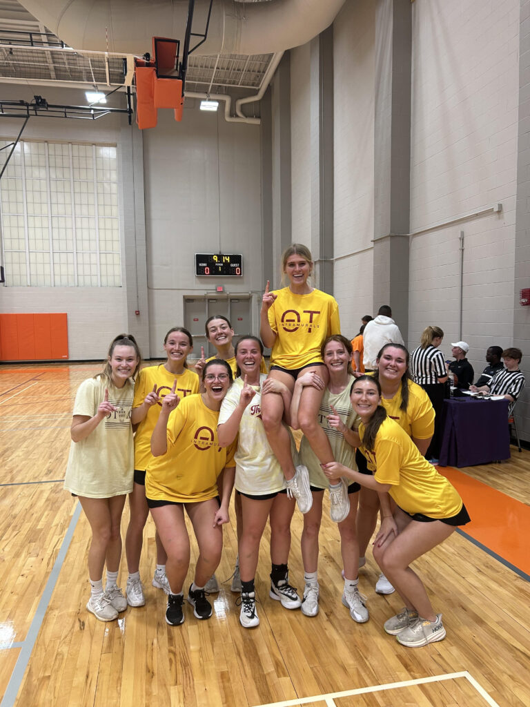 Paige (middle, black socks) holds her teammate up to celebrate their intramural victory