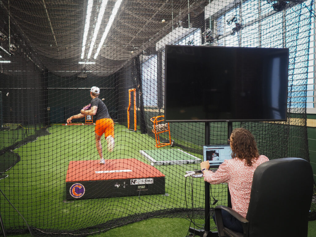 Amy Pope analyzing Lucas Mahlstedt's pitching data.