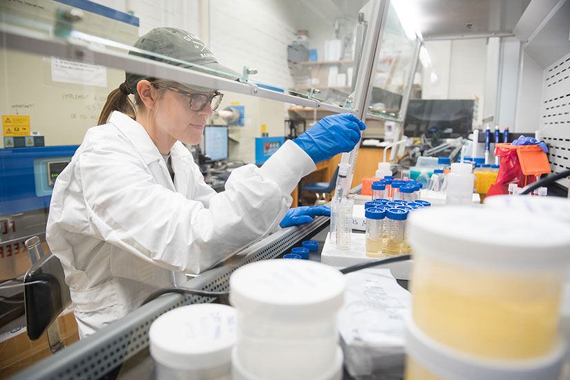 Female student in lab under hood.