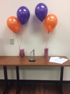 Award and purple and orange helium balloons