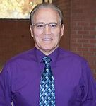 Head shot of Dr. Havice purple shirt and tie