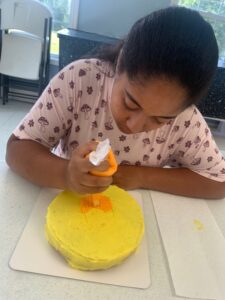 4-Her decorating a cake