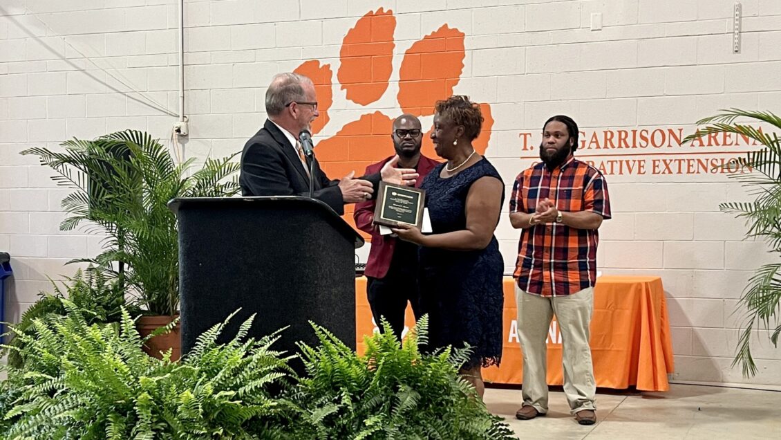 Three men with a woman accepting an award. 