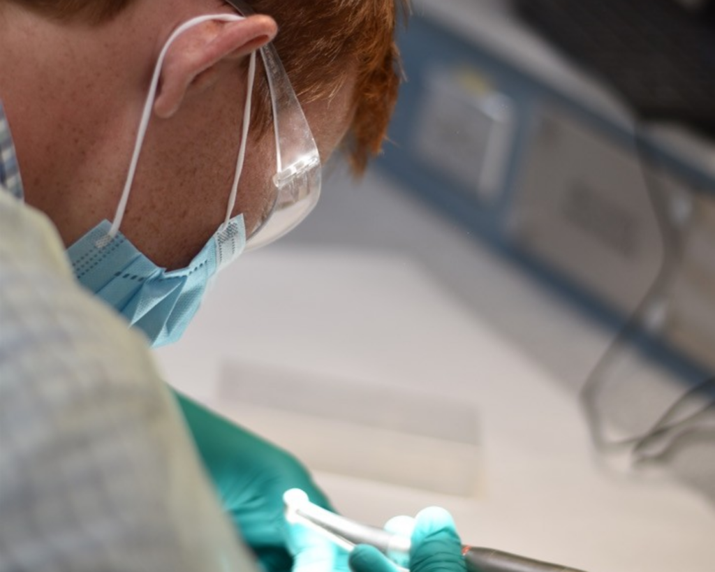 red headed man with mask on doing a science experiment.