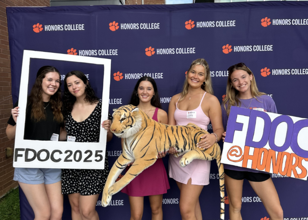 group of grils in front of a purple banner.