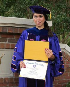 In an undated photo provided by Parastoo Amiri, Nazanin Zinouri poses for a photo with her PHD degree from Clemson University. Zinouri has a visa and has lived in the U.S. since August 2010. On Jan 20, 2017, Zinouri flew to Iran, expecting to have three weeks of family time with her mother, brother and sister. Instead, she was barely in Tehran before she began trying to get home to South Carolina. (Parastoo Amiri via AP)