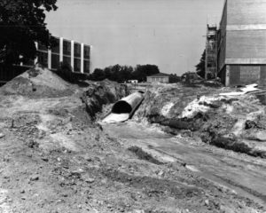 A photograph dated 1965 showing the construction of a steam and electric distribution tunnel.