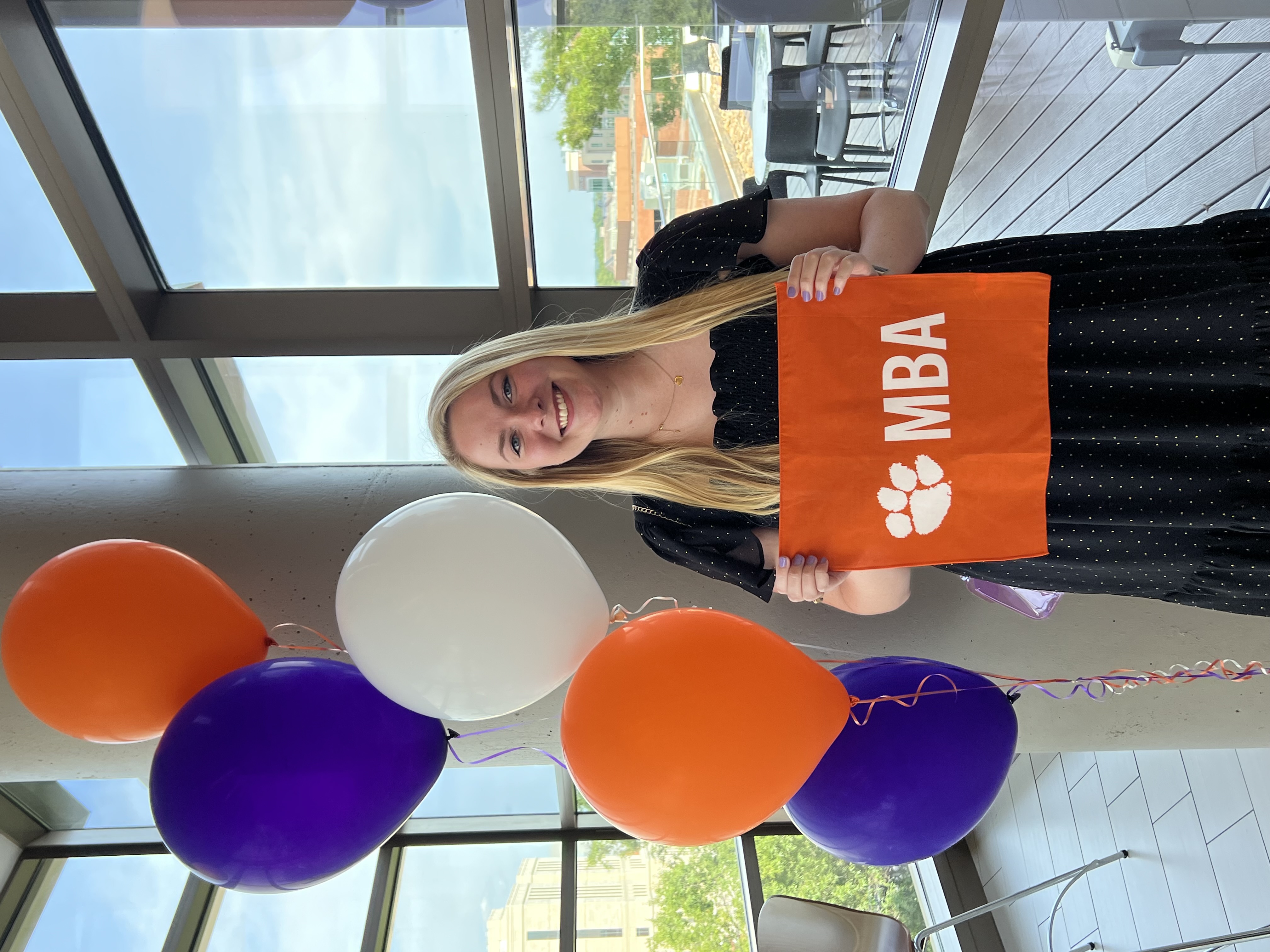 Chole Anderton holds the Clemson MBA Flag at her Tile Ceremony Graduation at Greenville ONE