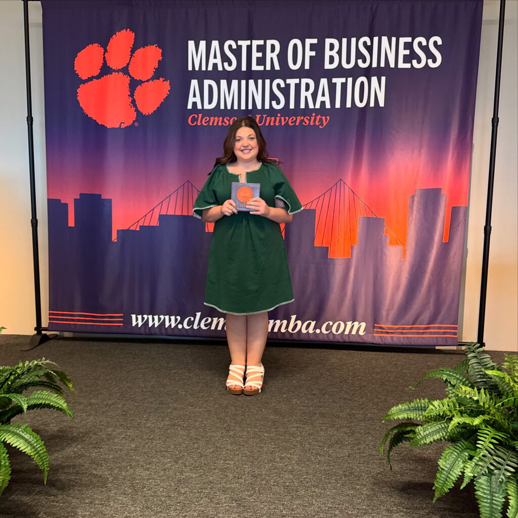 Woman standing in front of Masters of Business Administration banner 
