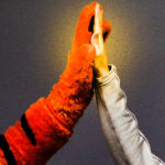 A closeup of the tiger mascot hand high-fiving a white human hand.