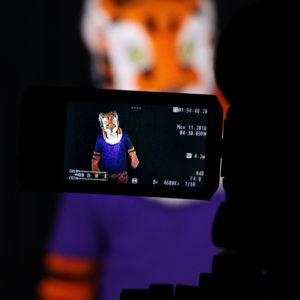 Image of the Clemson Tiger mascot through a video camera viewfinder. The Tiger mascot can also be seen in the background, out of focus.