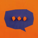 Orange and purple paper arranged in the shape of a speech bubble
