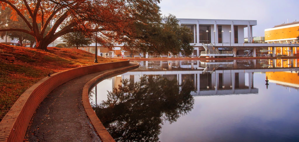 The R.M. Cooper Library is reflected in the fountain pond