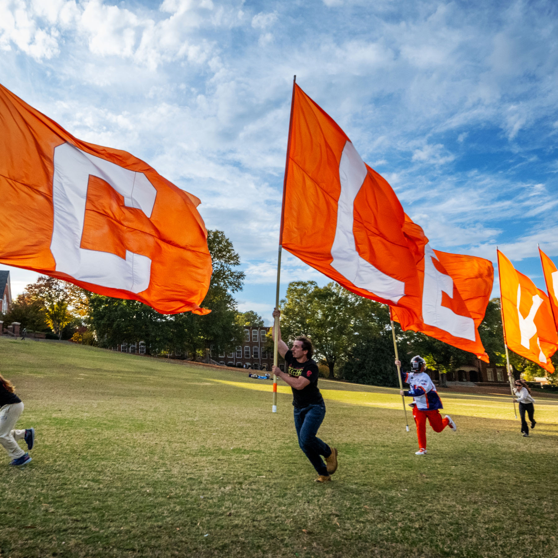 Image of Clemson students running with Clemson flags