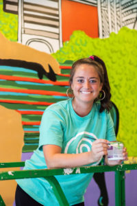 Clemson PRTM alumni Lacey Hennessey painting the mural in Clemson’s new Tipsy Taco restaurant. 