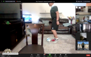 Picture of someone playing soccer in their living room.