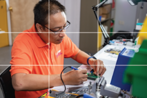man working with wires with grid lines displaying the rule of thirds
