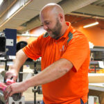 Kenny Tucker applies a plate to an anilox roll with stick-back tape