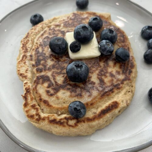 Oatmeal Pecan Pancakes topped with fresh blueberries and a pat of butter