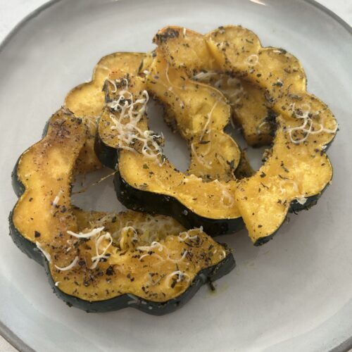 Rings of roasted acorn squash topped with parmesan cheese.