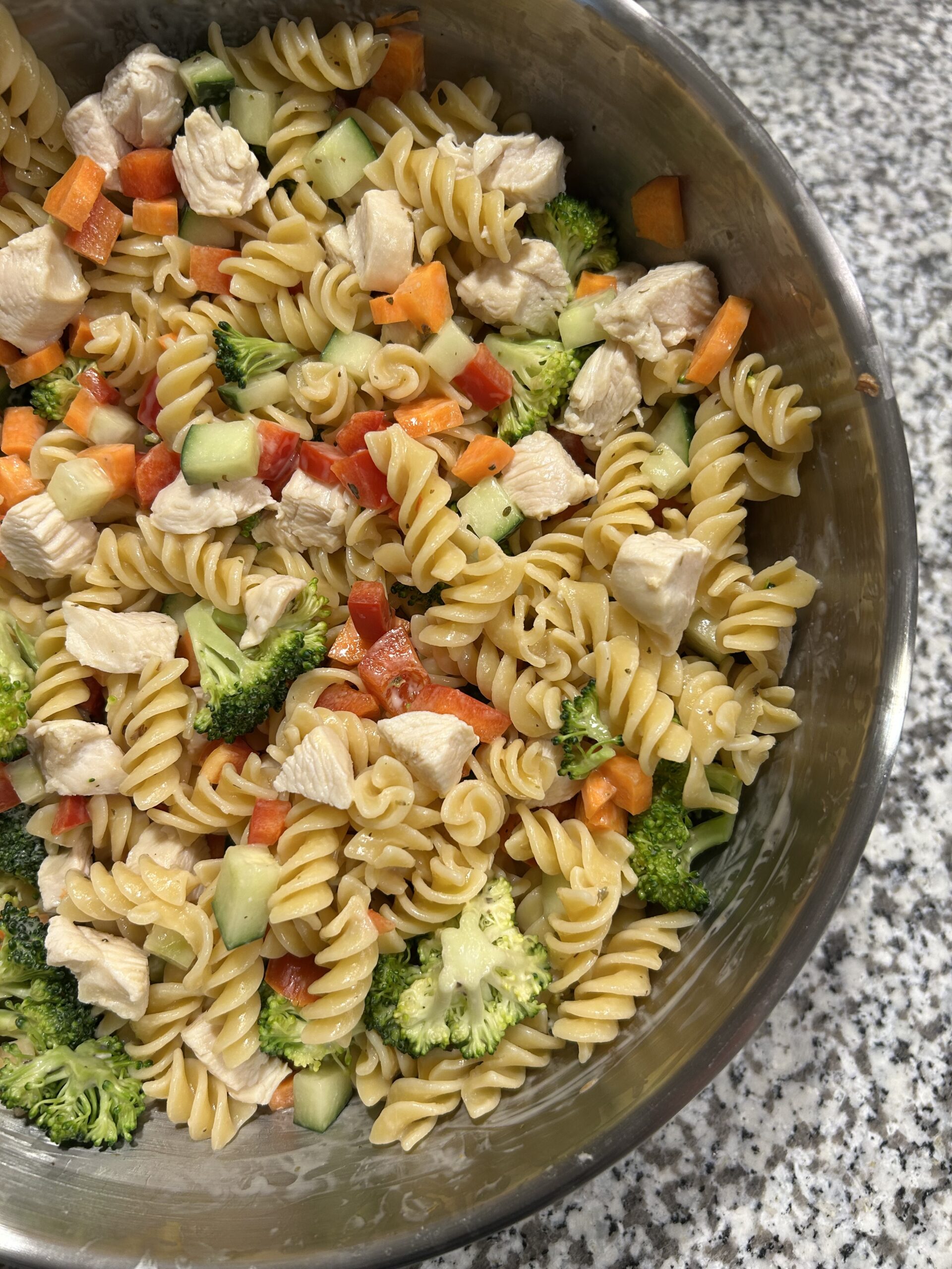Chicken and vegetable pasta salad - protein pasta is combined with a variety of vegtables such as chopped carrots, peppers, broccoli, and cucumber as well as boiled chicken and is then tossed in a light dressing which includes light mayonnaise, red wine vinegar and italian seasoning.