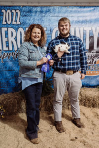 Rabbit Judge, Julia Waddell, presents Jason Connors and his Mini Rex rabbit, Gene, with the Grand Champion Ribbon.