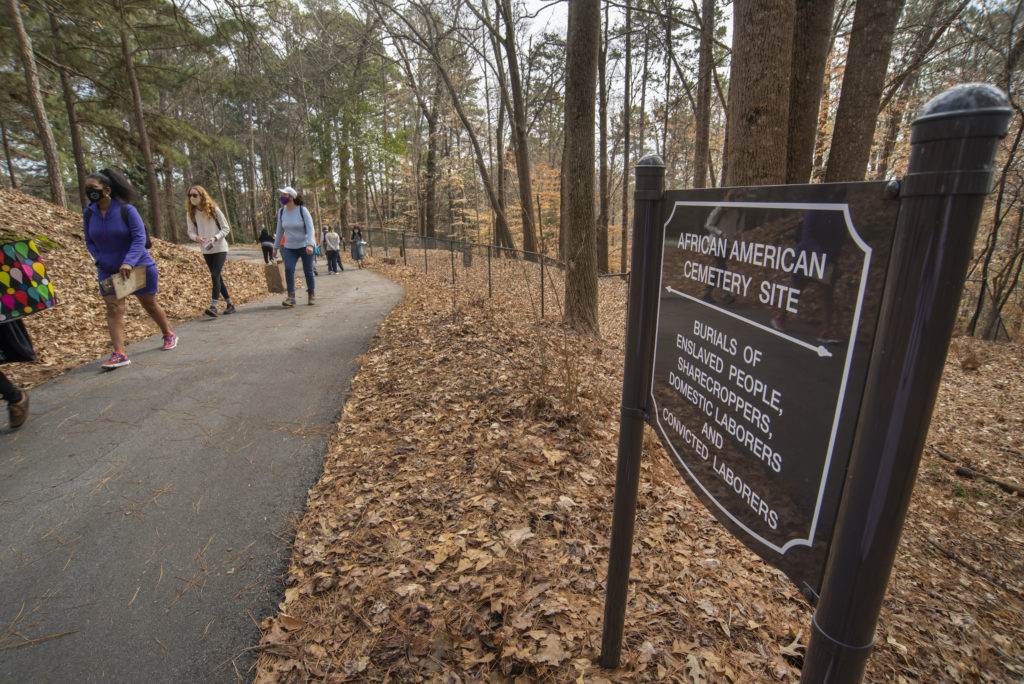 Visitors walk toward the western part of the African American Burial Ground in Woodland Cemetery.