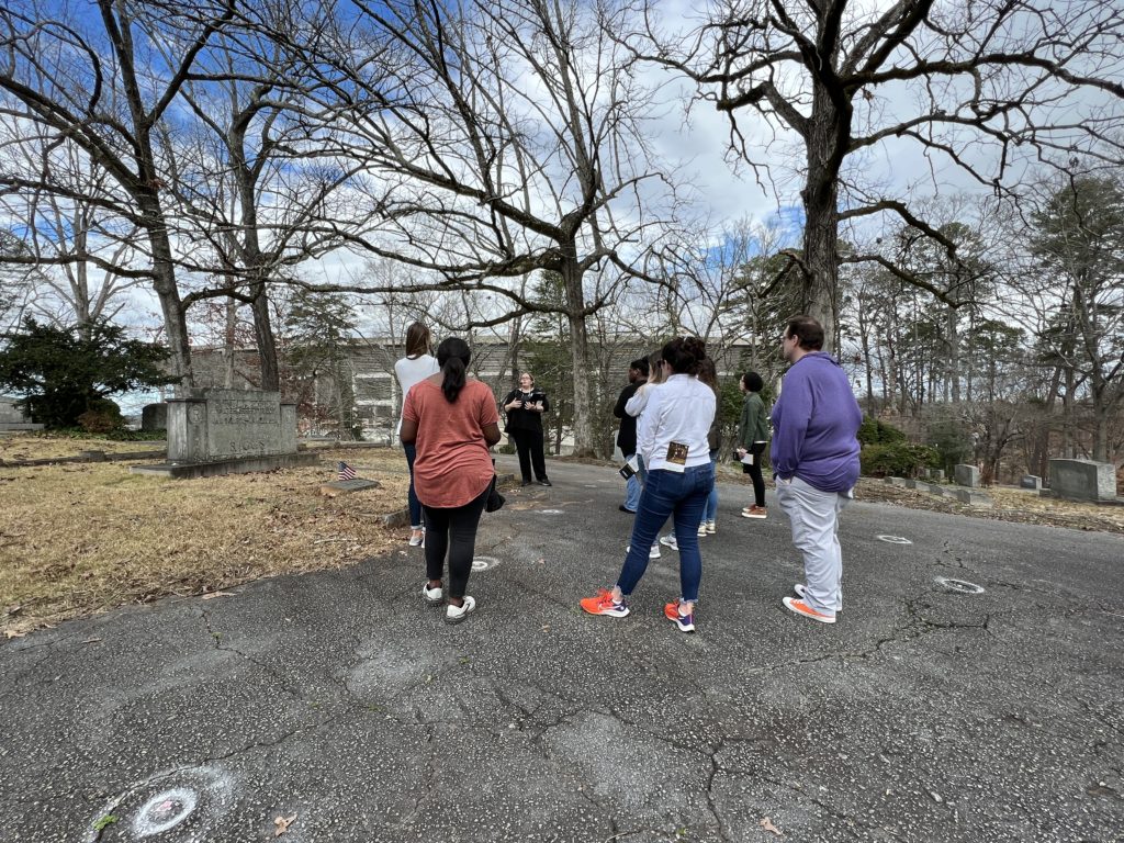 A group on campus takes a tour of the African American Burial Ground and Woodland Cemetery.
